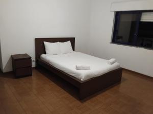 a small bed in a room with a window at Come Inn Costa da Caparica in Costa da Caparica