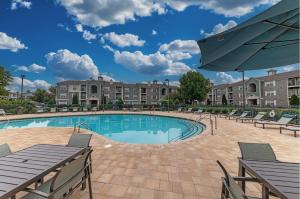 una piscina con sedie e un ombrellone di Landing at Preston at Hillwood - Murfreesboro a Murfreesboro