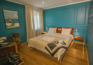 a bedroom with a bed with a blue wall at Fly House Faro in FAO