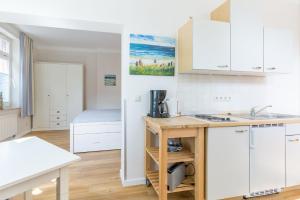 a kitchen with white cabinets and a sink at Haus Tarnewitz, Ferienwohnung 04 in Tarnewitz