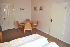 a room with a table and chairs and a bed at Hof Kröger Ferienwohnung Nr 04 in Travemünde