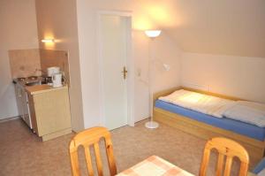 a small room with a bed and a table and chairs at Hof Kröger Ferienwohnung Nr 04 in Travemünde