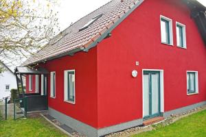 a red house with a red roof at schöne Ferienwohnungen an der Granitz in Blieschow +23 photos