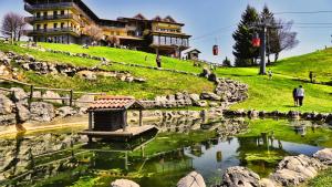 a man standing in front of a pond in front of a building at T'AMI Hotel Resort Spa in Selvino