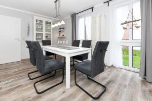 comedor con mesa blanca y sillas negras en Ferienhaus Strandidylle, en Carolinensiel 27 fotos más