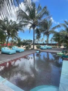 a swimming pool with palm trees in the background at BEACH HOUSE Tatajuba in Camocim