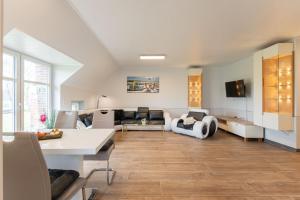 a living room with a couch and a table at Ferienwohnungen zum Lengener Meer 35527 - nur für Urlaubsgäste in Uplengen
