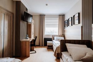a hotel room with two beds and a desk at HOTEL AVIA Ekotrans in Piotrków Trybunalski