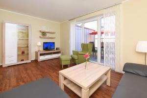 a living room with a couch and a table at Ferienhaus Relax - Uns Huus an t Küst in Bensersiel