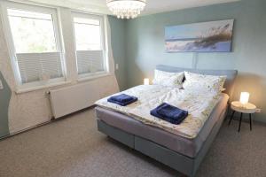 a bedroom with a bed with two blue towels on it at Ferienhaus Schnitterkarten - nur an Feriengäste - ABC366 in Klütz