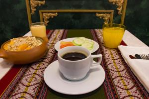 a table with a cup of coffee and a plate of food at Avraham Hotels in Machu Picchu +47 photos