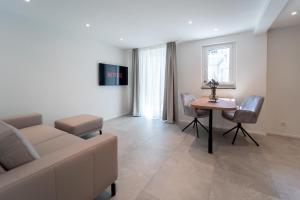 a living room with a couch and a table at Privat-SPA mit Whirlpool und Sauna für 5 Personen! in Winterthur