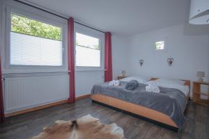 a bedroom with a bed and two large windows at Ferienwohnungen an der Marcusheide in Worpswede +16 photos
