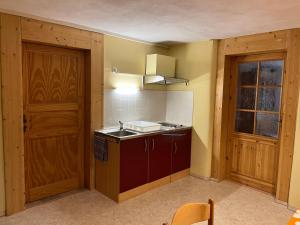 a small kitchen with a sink and a door at Ferienwohnung mit Garten und Ostseenähe OVS 111 in Rakow