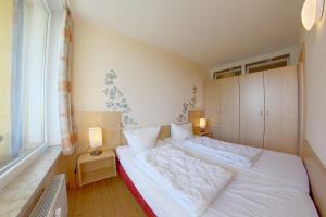 una camera da letto con un letto bianco e una finestra di Apartment 518 a Hohegeiss