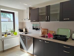Una cocina con gabinetes negros y un fregadero y una ventana. en Rügen Fewo 303, en Gingst