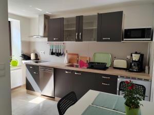 una cocina con armarios negros y una mesa con sillas en Rügen Fewo 303, en Gingst