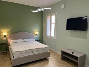 a bedroom with a bed and a flat screen tv at Residenza Lidia e Giulia in Grottammare