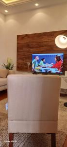 un soggiorno con una TV a schermo piatto su una parete di Irina Blessed Homes Bonanjo a Douala