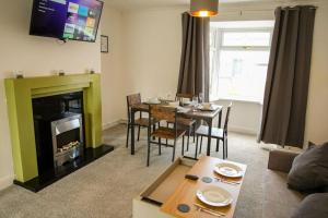 a living room with a table and a fireplace at Spacious 3 Bedroom Home on South Shields Coast in Westoe