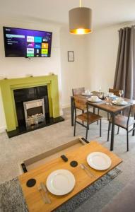 a living room with a table and a fireplace at Spacious 3 Bedroom Home on South Shields Coast in Westoe +31 photos