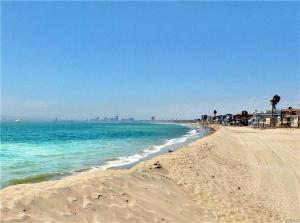 a sandy beach with the ocean and buildings in the background at Sand Sun & Second - Charming Studio within Walking Distance to Beach in Long Beach
