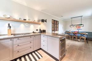 una cucina con armadi bianchi e una sala da pranzo di Ferienhaus Silbermöwe 7d a List