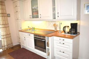 Una cocina con gabinetes blancos y un fregadero. en Residenz Niendorf Elegante Ferienwohnung Nr 13, en Niendorf