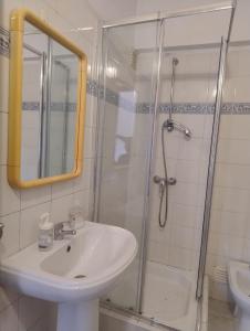 a bathroom with a sink and a shower at Come Inn Costa da Caparica in Costa da Caparica