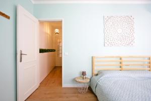 a bedroom with a bed and a door leading to a hallway at Apartamento SofiSara in Tavira +2 photos
