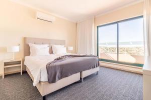 una camera da letto con un letto e una grande finestra di Pestana Gramacho Residences a Ferragudo Altre 61 foto