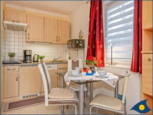 una pequeña cocina con mesa con sillas y mesa en Haus Kieferndüne Ferienwohnung EG, en Ahlbeck 5 fotos más