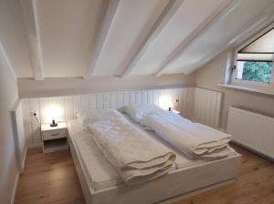 a large white bed in a room with a window at Gästehaus Harzklause 6 in Sieber +6 photos