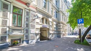 a building with a parking sign next to a street at Mosaic Hotel in Riga