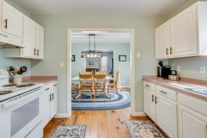 una cucina con armadi bianchi e una sala da pranzo con tavolo di Victorian Cottage a Chincoteague