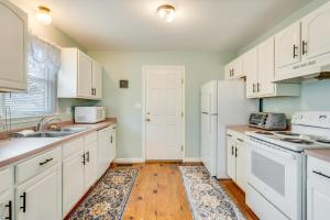 una cucina con mobili bianchi e un frigorifero bianco di Victorian Cottage a Chincoteague Altre 19 foto