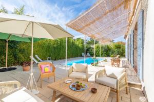Un patio con una mesa y sillas y una sombrilla. en Villa Azul - Welkeys, en Bandol