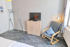 Habitación con TV, silla y TV. en Altstadt-Fairmietung Erdgeschoss - ABC544, en Wismar