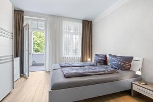 a bedroom with a bed and a large window at Appartements Villa Glückspilz OFC 27 in Kühlungsborn +30 photos