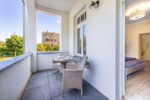 a balcony with a table and chairs and a window at Appartements Villa Glückspilz OFC 27 in Kühlungsborn
