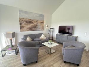 SehestedtにあるFerienhaus Weitblickのリビングルーム(ソファ、椅子2脚、テレビ付) +12枚の写真