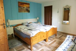 Un dormitorio con una cama con una pared azul. en Kos - Bungalow "Kapitänskajüte ", en Ostseebad Koserow