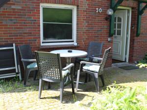 a table and chairs in front of a brick building at Appartement "Deichblick" - Nordseebad Burhave in Burhave