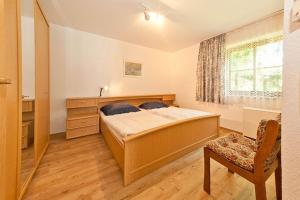 une chambre avec un lit, une chaise et une fenêtre dans l'établissement Ferienwohnungen im Feriendorf Reichenbach Nr 10, à Nesselwang 18 autres photos