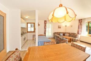 Il comprend une cuisine et un salon avec une table en bois. dans l'établissement Ferienwohnungen im Feriendorf Reichenbach Nr 10, à Nesselwang