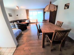 un salon avec une table et des chaises en bois dans l'établissement Ferienwohnungen im Feriendorf Reichenbach Nr 10, à Nesselwang