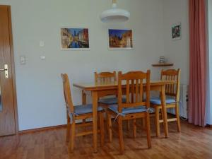 une table à manger avec quatre chaises et une table dans l'établissement Ferienwohnungen im Feriendorf Reichenbach Nr 11, à Nesselwang
