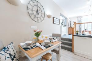 a kitchen and dining room with a table and a clock on the wall at Ironbridge View Townhouse - WINNER 2026 UK MOST PICTURESQUE SELF-CATERING HOLIDAY HOME & 2026 SELF-CATERING ACCOMMODATION OF THE YEAR in Ironbridge