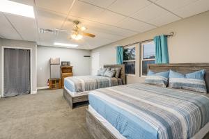 Dos camas en un dormitorio con cortinas azules. en Shared Outdoor Space Quaint Studio in Fredonia, en Fredonia