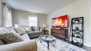 a living room with a couch and a tv at Family Retreat Near Yale - Stylish Free Wifi in New Haven